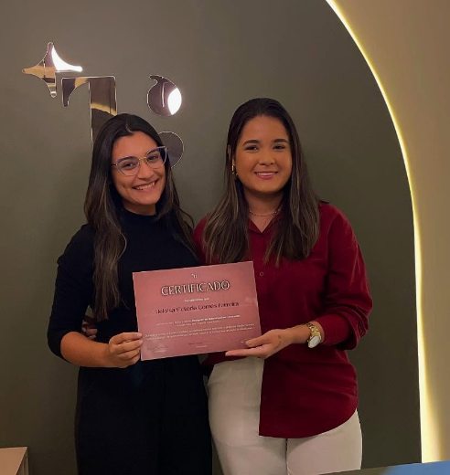 Heloísa com o certificado, ao lado da Thainá