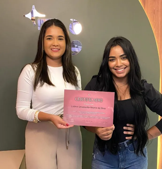 Esther com o certificado, ao lado da Thainá